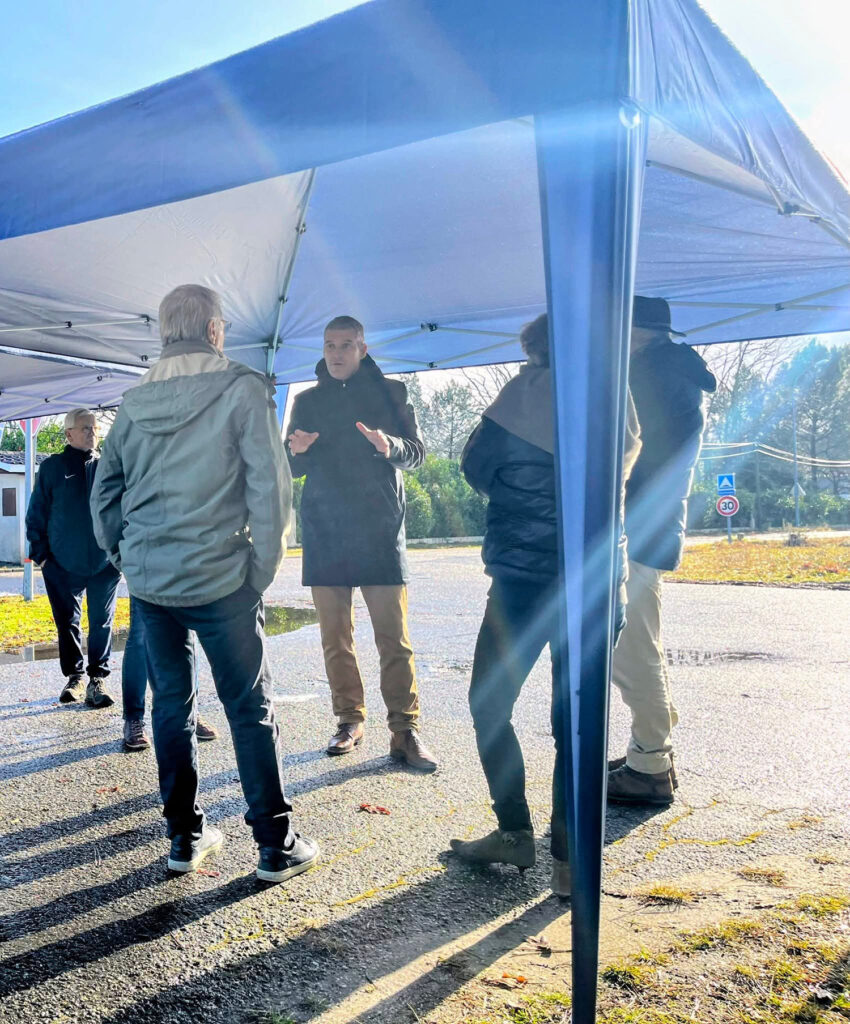 Discussion entre habitants sous un barnum lors de la réunion de quartier